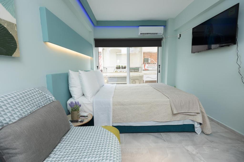 1 dormitorio con 1 cama, TV y sofá en EllMar - new & modern studio in the center, en Chalkida