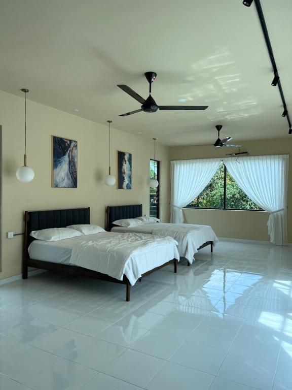 a bedroom with two beds and a ceiling fan at Eleven8 Taman Pandan in Alor Setar