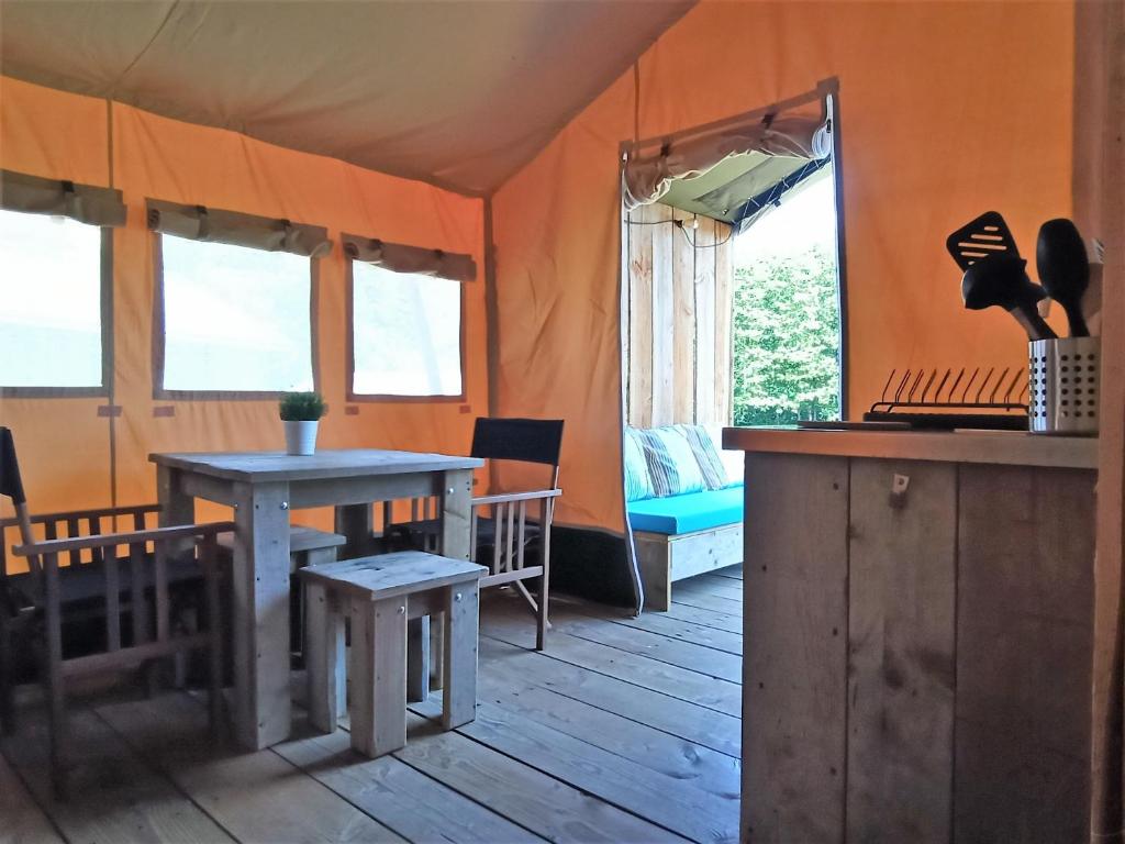 an inside of a tent with a table and chairs at Le Lodge du Hibou in Quarré-les-Tombes