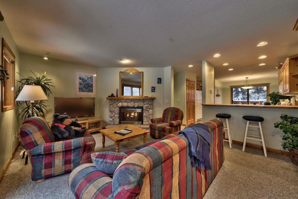 a living room with two couches and a fireplace at Snow Creek Village #20 By Bear Country in Sun Peaks