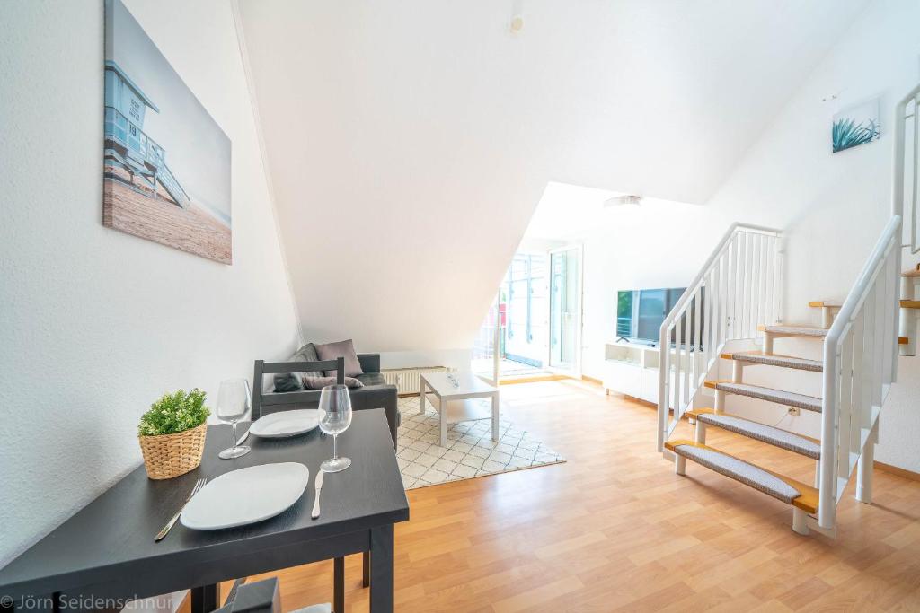 a living room with a dining table and stairs at Edle DG Maisonette mit Balkon, Wohnzimmer, Arbeitszimmer, Waschmaschine, Top Ausstattung, zentral in Fürstenwalde