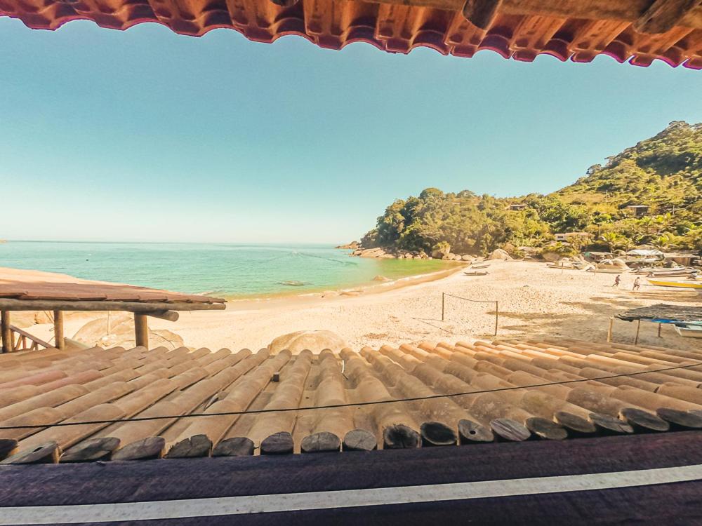 uma vista para uma praia com um grelhador e para o oceano em Chalé na Praia de Ponta Negra em Ponta Negra