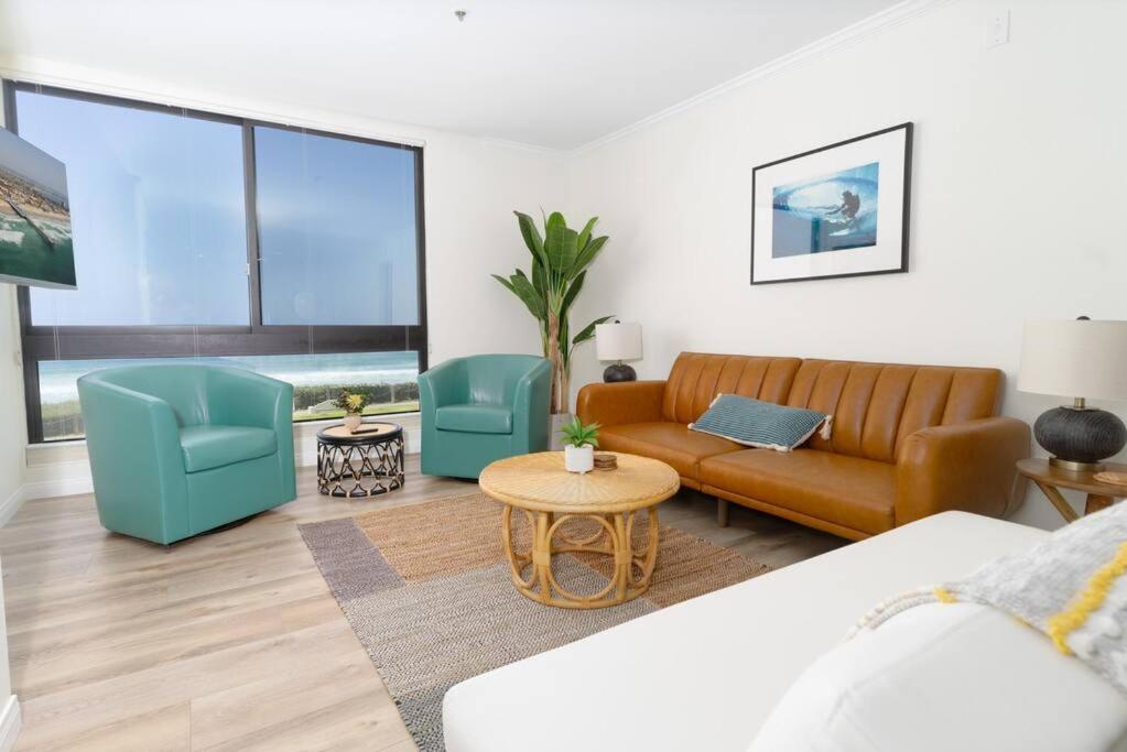 ein Wohnzimmer mit einem Sofa und 2 Stühlen in der Unterkunft Sunny BEACH FRONT 2BR Condo on the Water in San Diego