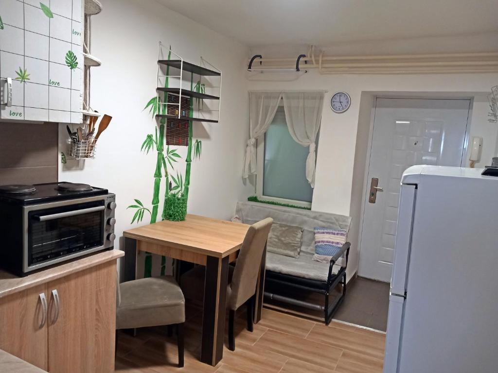 a kitchen and dining room with a table and a couch at Studio apartment Novi Sad in Novi Sad