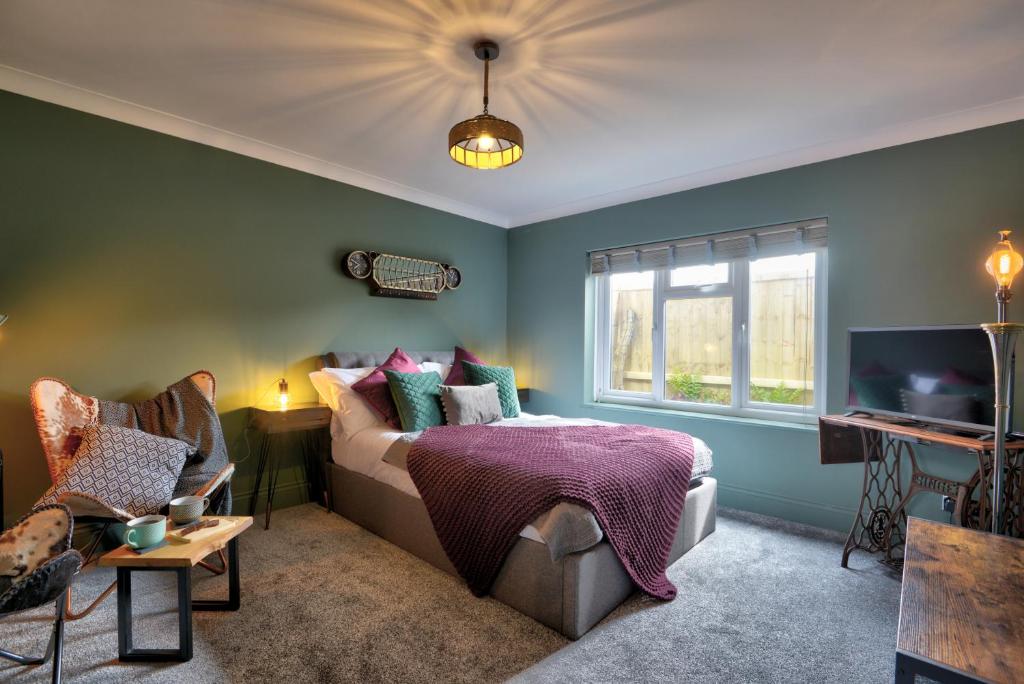 a bedroom with a bed and a tv and a window at Annex by the Sea in Lancing