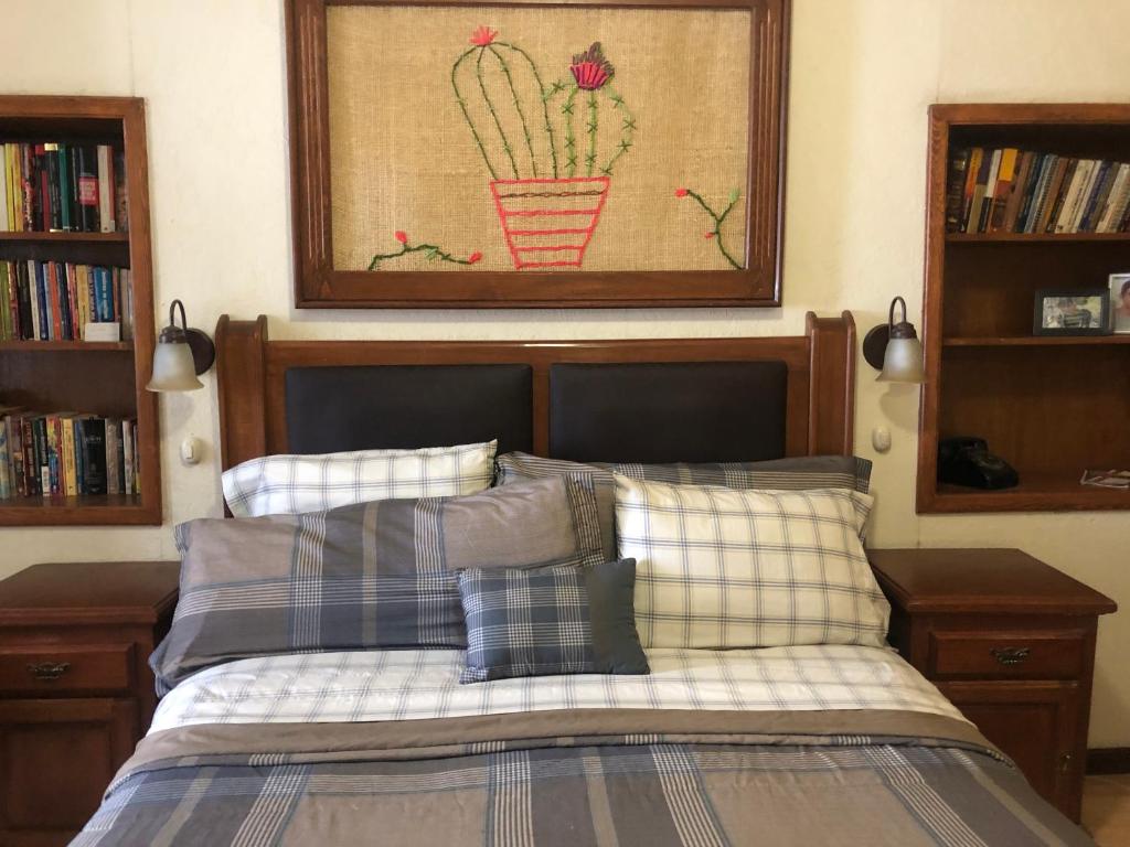 1 dormitorio con 1 cama y una foto de un cactus en Home Stay María, en Hidalgo del Parral