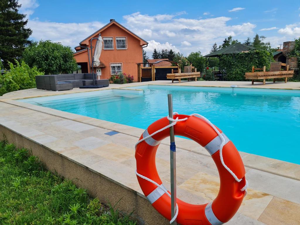 einen Pool mit einem roten und weißen Schwimmerhaken in der Unterkunft Vila Tea Fruska Gora in Čortanovci