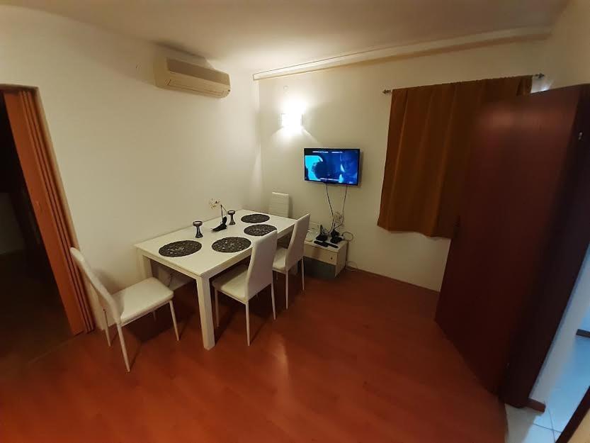 a small room with a table and a television at APARTMANI DELAS in Pješčana Uvala
