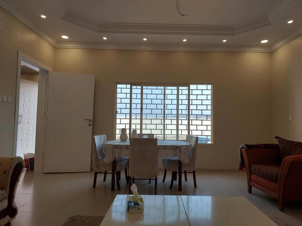 a dining room with a table and chairs and a window at استراحة في منطقة مرتفعة بالقرب من أبها in Abha