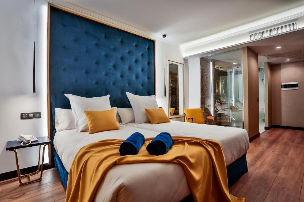 a bedroom with a large bed with blue headboard at Design Plus Bex Hotel in Las Palmas de Gran Canaria