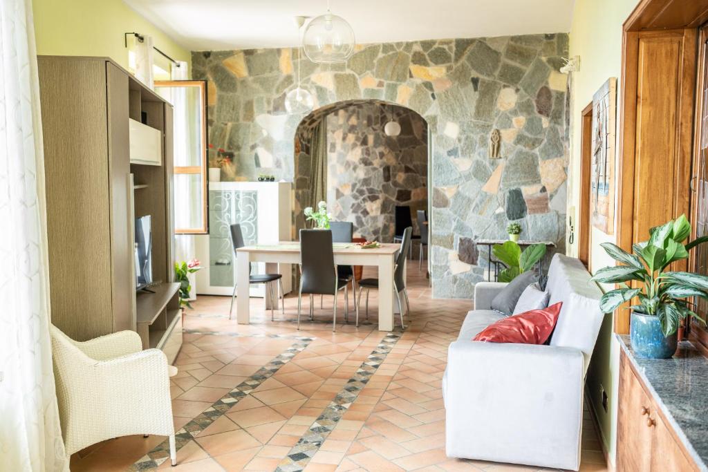 ein Wohnzimmer mit einem Tisch und einer Steinmauer in der Unterkunft Casa Donna Grazia - Cilento in Orria