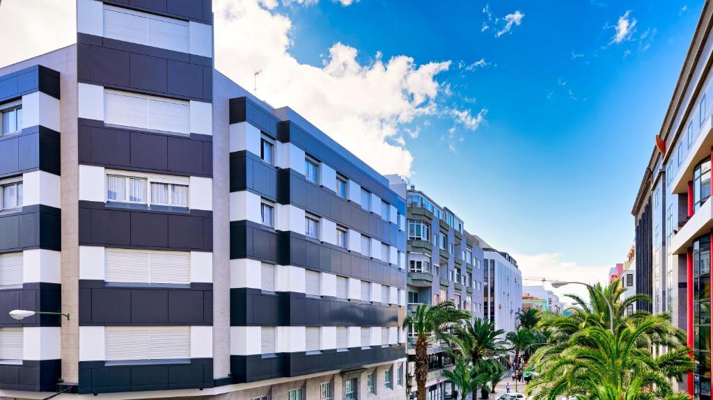 un edificio alto en una ciudad con palmeras en Bex Holiday Homes, en Las Palmas de Gran Canaria