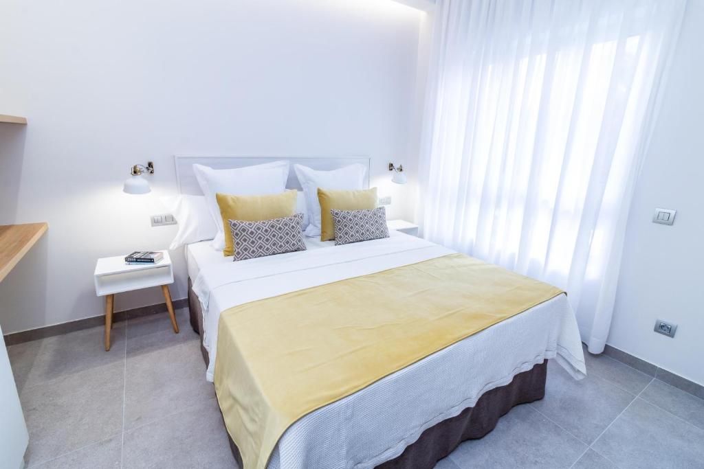 Un dormitorio con una gran cama blanca con almohadas. en Bex Holiday Homes, en Las Palmas de Gran Canaria