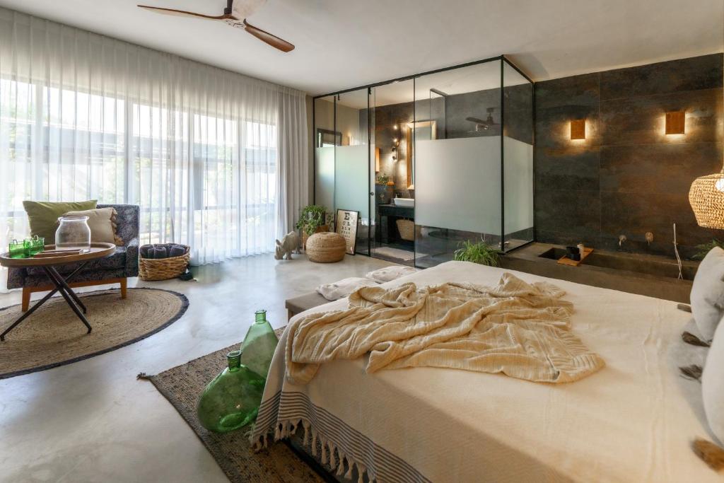 a bedroom with a large bed with a glass wall at גלילה - סוויטת בוטיק רומנטיות לזוגות עם האט טאב פרטי ליד הים in Bustan HaGalil