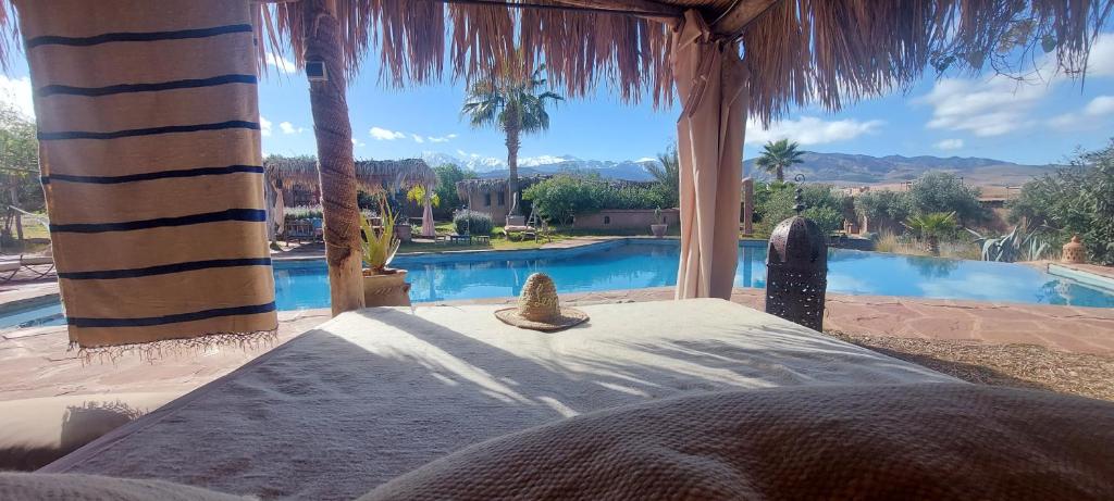 Cama en habitación con vistas a la piscina en Les Jardins de Taja, en Ourika