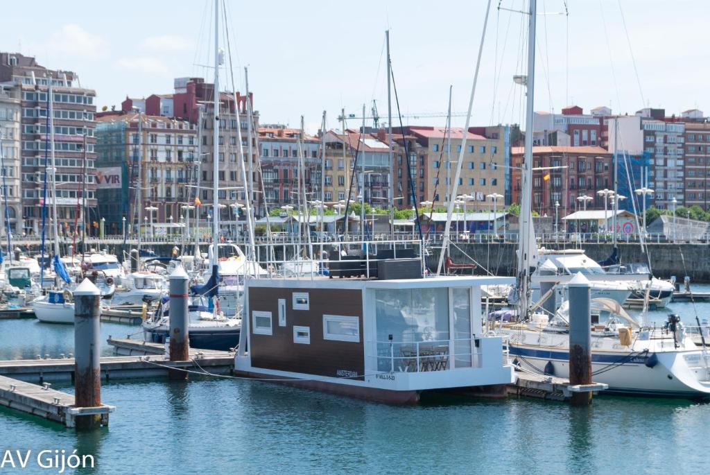 a small boat docked at a marina with other boats at AV Amsterdam Casa Flotante in Gijón