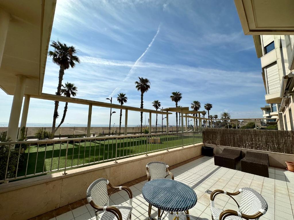 a table and chairs on a balcony with a view of the beach at Reinapart Patacona Beachfront Seaview in Valencia