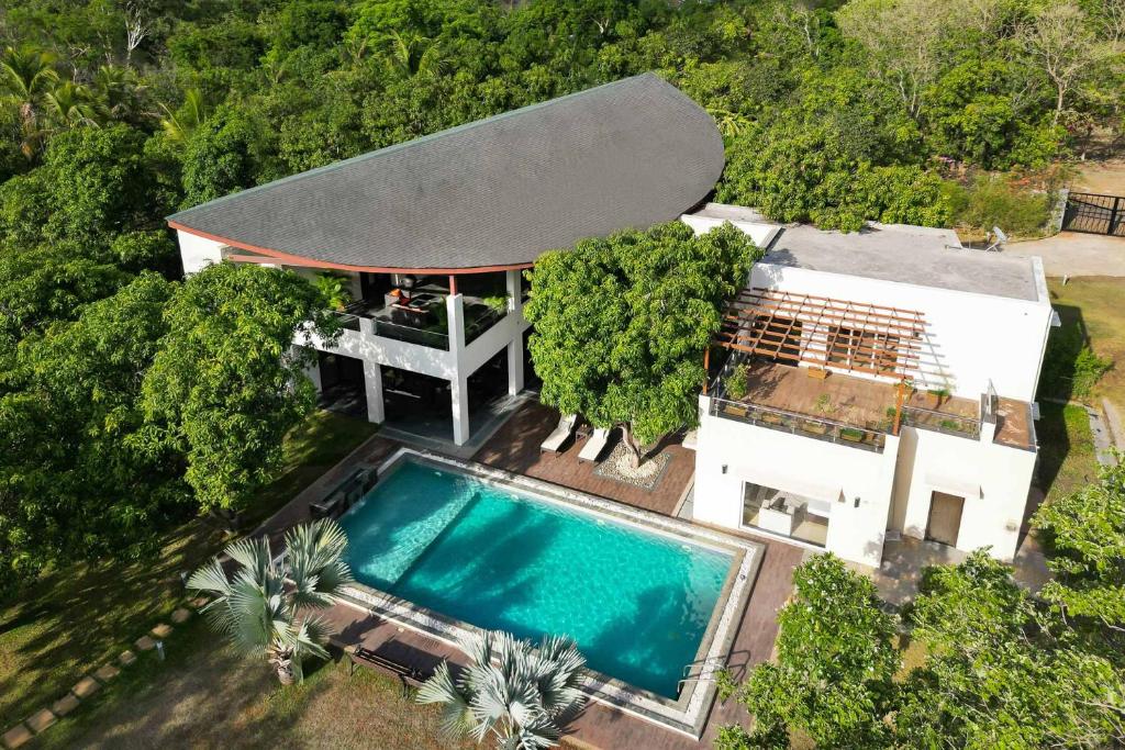 uma vista superior de uma casa com piscina em The Leaf by StayVista - An enchanting escape offering a pool, terrace, lush lawn, contemporary interiors, and indoor games em Alibaug
