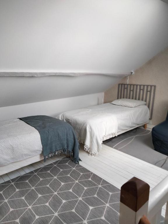 2 Betten nebeneinander in einem Zimmer in der Unterkunft La Brousse Kacha in Malleret-Boussac