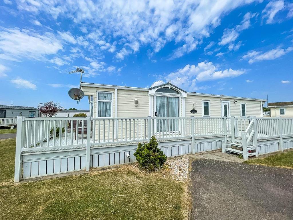 a white fence in front of a white house at Brilliant Caravan For Hire At Manor Park In Hunstanton Norfolk Ref 23176k in Hunstanton
