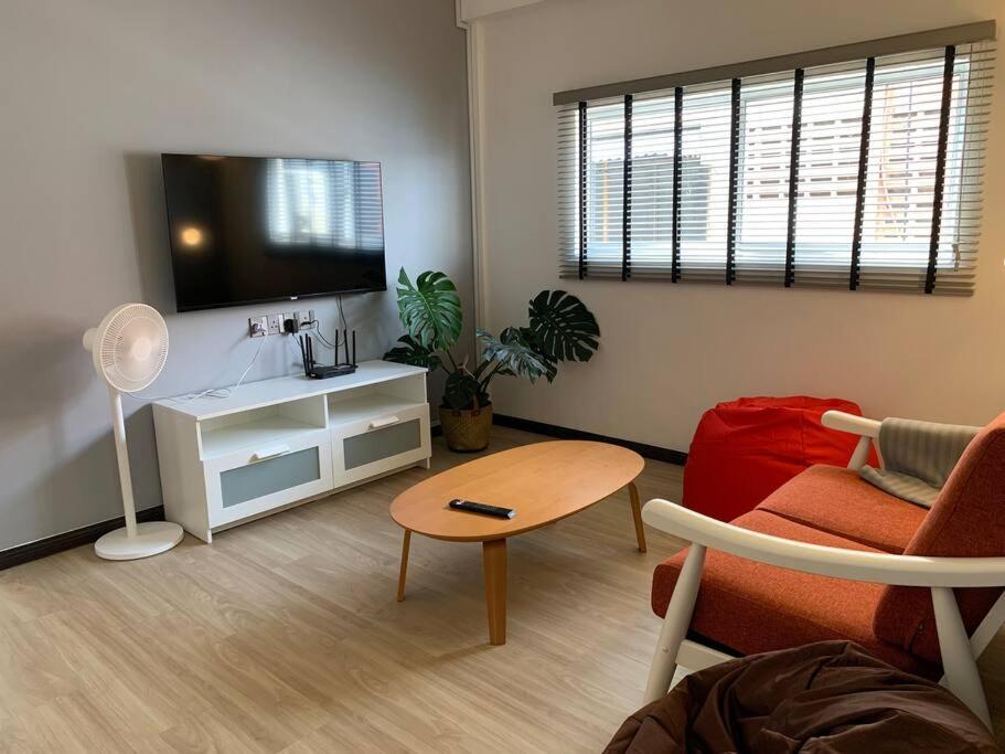 a living room with a tv and a couch and a table at Entire house in town centre #WIFI#NETFLIX in Kuala Terengganu