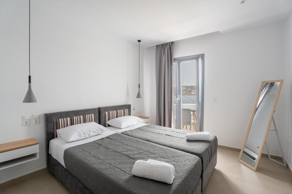 a bedroom with a large bed and a mirror at Liana sunset in Mýkonos City