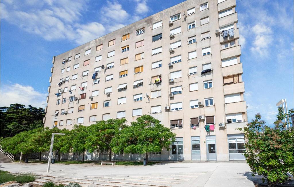 a large white building with trees in front of it at 1 Bedroom Lovely Apartment In Pula in Pula