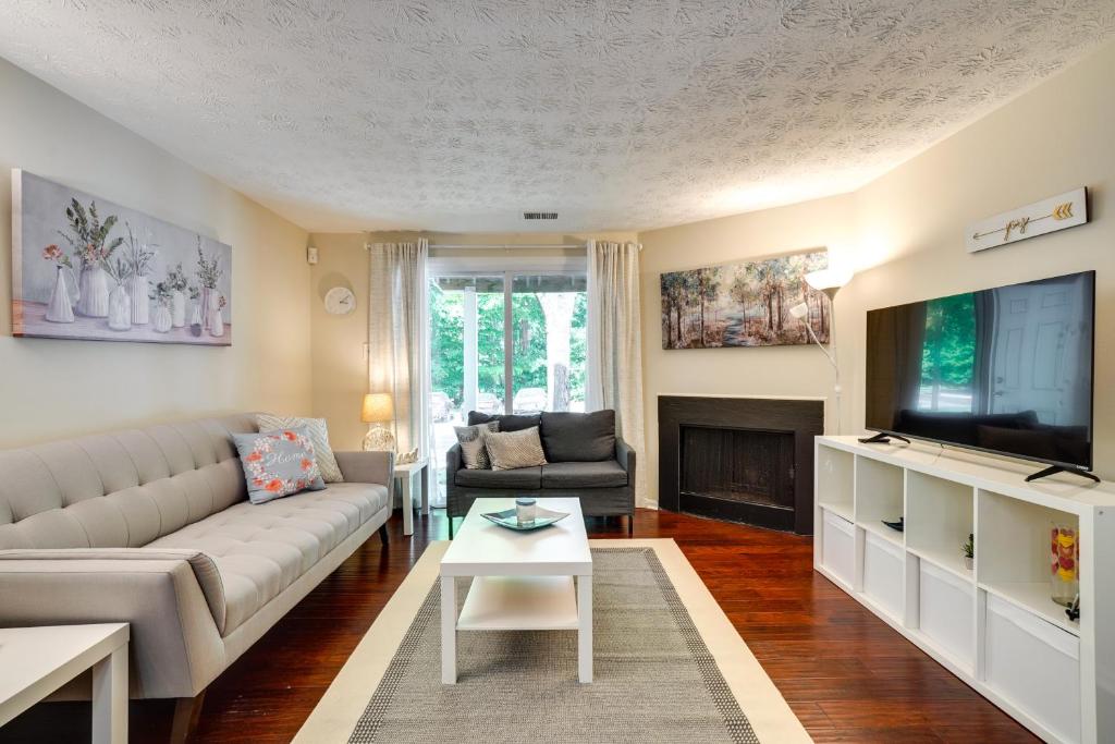 a living room with a couch and a tv at Quiet Columbia Condo Near Parks and Pool! in Columbia