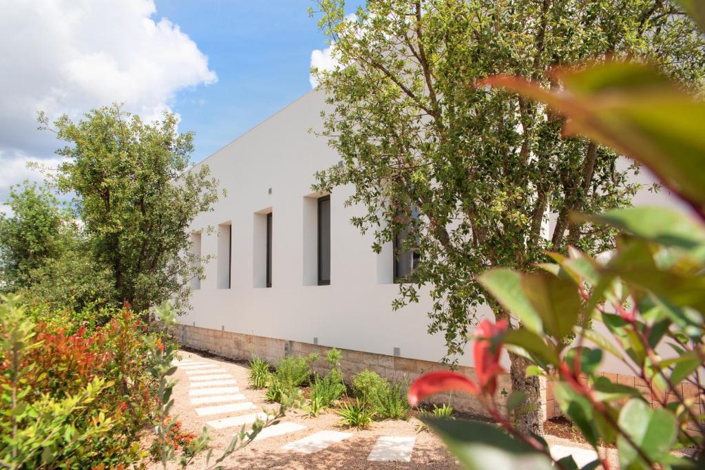 a rendering of a white building with trees at Lisetta Gardens Boutique & Suites in Cisternino