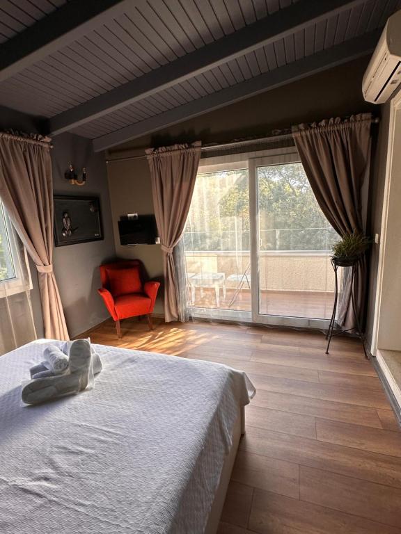 a bedroom with a bed and a large window at Erythros Hotel in Çeşme