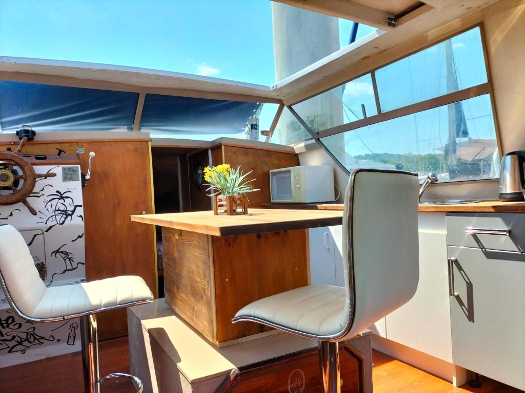 una camera con scrivania e sedie in barca di Bateau PEARL a Rouen