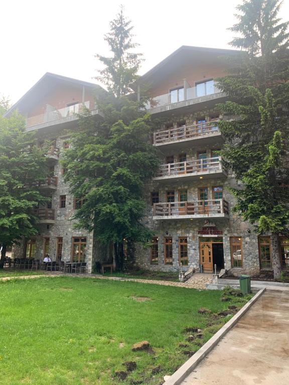 ein großes Steingebäude mit Bäumen davor in der Unterkunft Fusha e Gjes Hotel in Valbonë