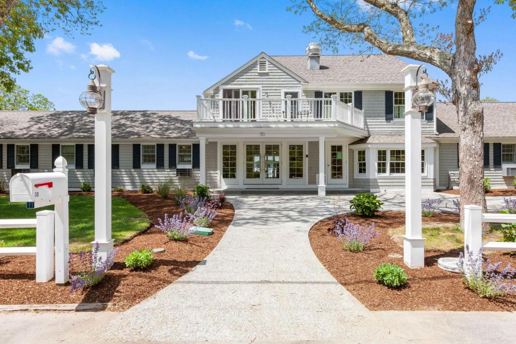 a white house with a porch and a driveway at Pelham on Earle in West Harwich