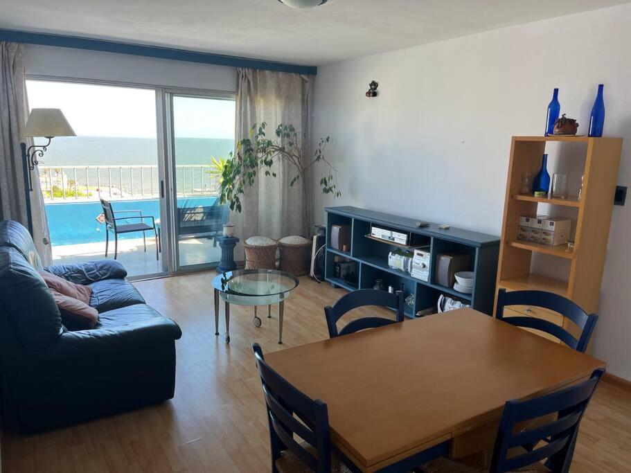 a living room with a couch and a table with a view of the ocean at Apto próximo a casco histórico in Montevideo