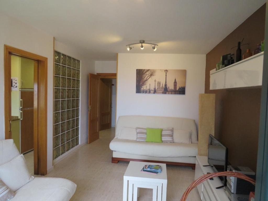 a living room with a white couch and a table at ISLA LUNA. (familias/parejas) in Isla