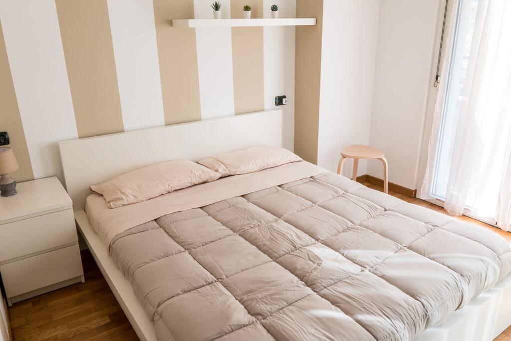 米蘭的住宿－Santa Giulia Connect，卧室内的一张大床,拥有白色的墙壁