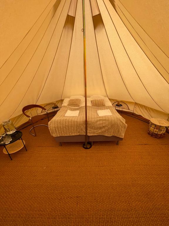 - une chambre avec un lit dans une tente dans l'établissement Glamping Tent Mariehamn, à Mariehamn