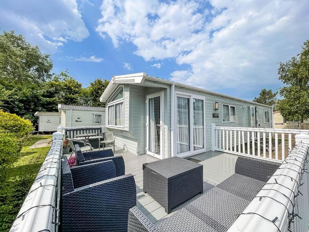 a small house with a deck with chairs on it at Beautiful 6 Berth Caravan At Southview Holiday Park In Skegness Ref 33031s in Skegness