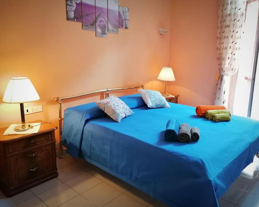 Una cama azul con dos pares de zapatos. en Appartamento Torino-zona Politecnico, en Turín