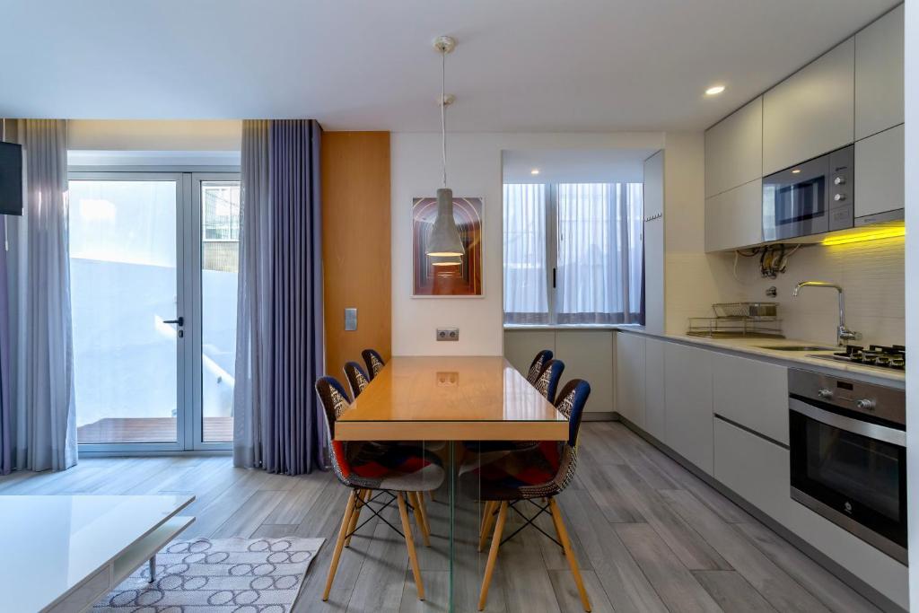 uma cozinha com uma mesa de jantar e cadeiras em Bright Lisbon T2 with 35 m2 Terrace, 2bed and 2bath and fast internet! em Lisboa