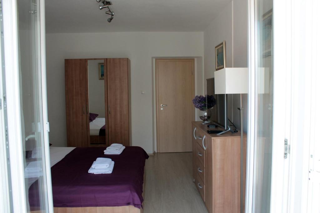 - une chambre avec un lit et un miroir dans l'établissement Cozy Apartment Skalini, à Dubrovnik