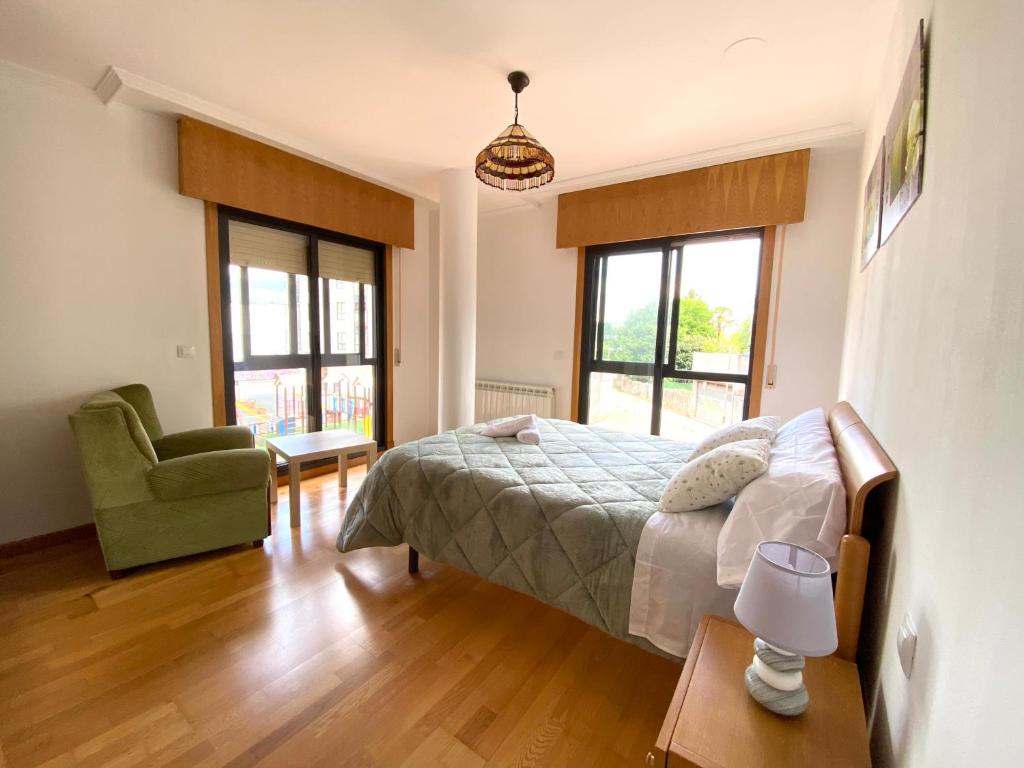 1 dormitorio con 1 cama, 1 silla y ventanas en RAIOLA, en Porriño
