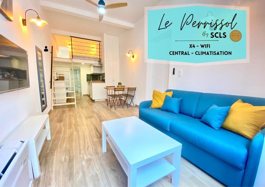 ein Wohnzimmer mit einem blauen Sofa und einem Tisch in der Unterkunft Le Perrissol By SCLS Locations in Cannes