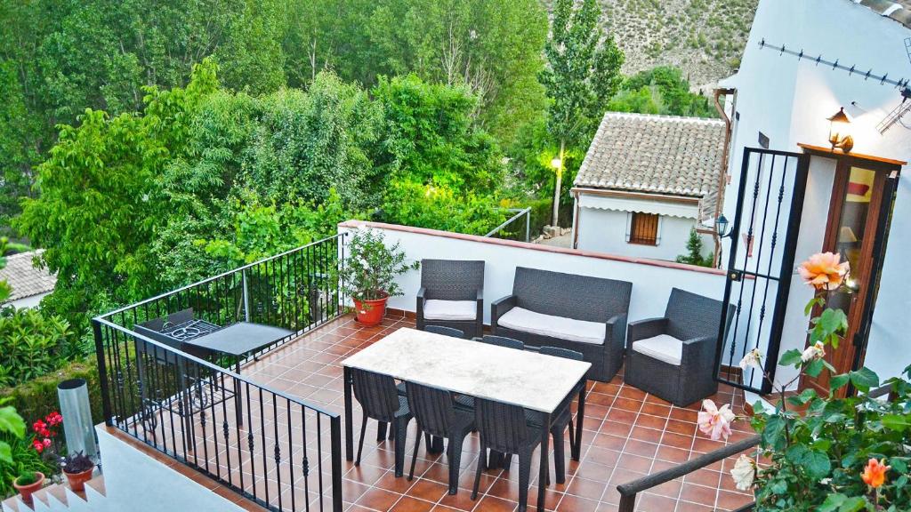 eine Terrasse mit Tisch und Stühlen auf einem Balkon in der Unterkunft Casa Rural Cortijo el Plantío in Castril