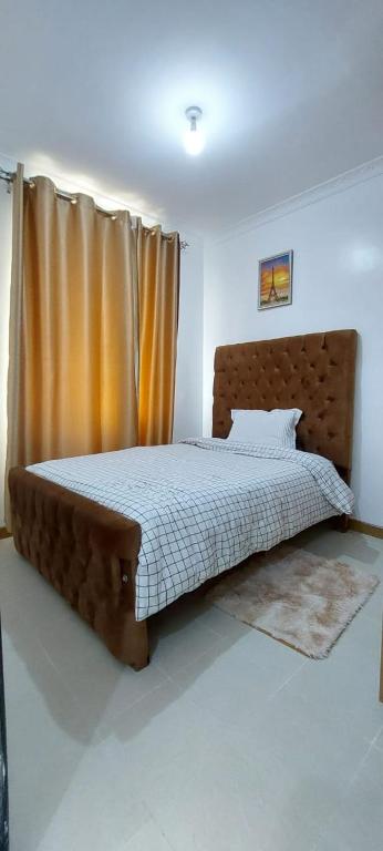 una camera con un grande letto con testiera in legno di Happy Homes Airbnbs Ngara, Nairobi a Nairobi