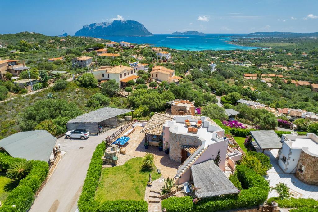 een luchtzicht op een huis met de oceaan op de achtergrond bij Villa Majra - Klodge in Olbia
