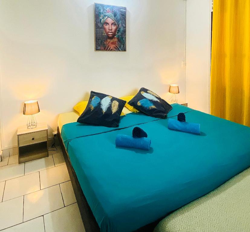 1 dormitorio con 1 cama grande con sábanas azules en Auberge K-WAN Hostel, en Deshaies