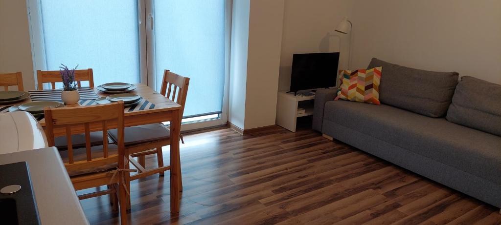 ein Wohnzimmer mit einem Tisch und einem Sofa sowie ein Esszimmer in der Unterkunft Apartamenty Niko in Zator