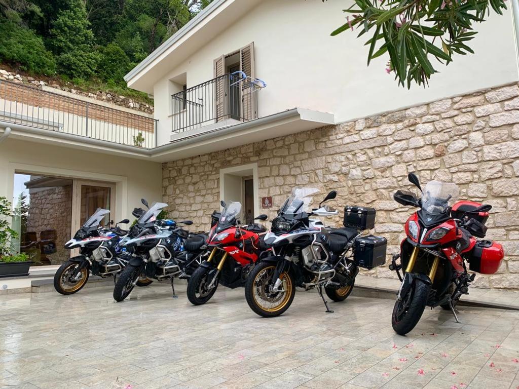 a row of motorcycles parked in front of a building at Tarsis Guest House in Baunei