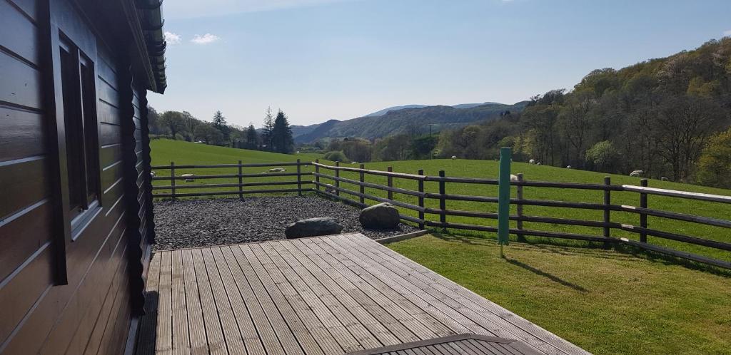 a porch of a house with a fence and a field at Amazing Views Log Cabin Broughton Mills South Lakes in lower hawthwaite